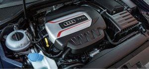 Audi engine bay showing the coolant expansion tank and cooling-system hoses