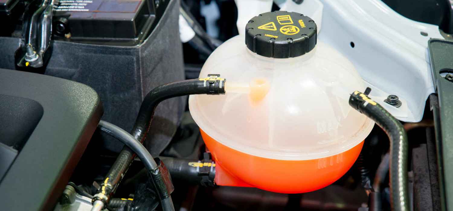 Coolant expansion tank and connected hoses in an engine bay